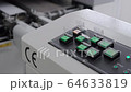 Engineer monitors and adjusts the surface mount conveyor for LEDs 64633819