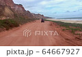Tourists by the cliffs bordering the sea near Gunga beach in Alagoas, Brazil 64667927
