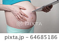 Pregnant woman using digital tablet 4K 64685186