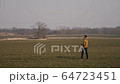young sports man runs in the field and launches a boomerang into the sky 64723451