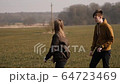 young couple in love together launch a boomerang in a field 64723469