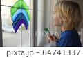 Little boy drawing on window rainbow while coronavirus quarantine. Rainbow sign is symbol of hope, means that everything will be OK. Stay home for lockdown coronavirus. 64741337