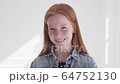 Cheerful smiling face of beautiful teen girl with freckles and red hair 64752130