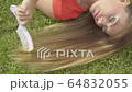 Woman with long hair lying on grass outdoor 4K 64832055