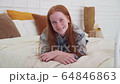 Pretty teenage girl with freckles smiling at bedroom 64846863