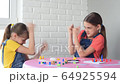Two girls play board games and fight arcs with a friend 64925594