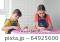 Two girls enthusiastically play a board game at home 64925600