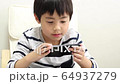 A boy using a smartphone 64937279