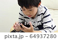 A boy using a smartphone 64937280