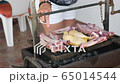 happy elderly lady cooking on a barbecue together with her family 65014544
