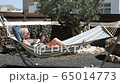 Senior woman looking on cell phone relaxing on a hammock in home garden, fuerteventura spain 65014773