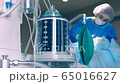 The operation of the ventilator piston, against the background of a doctor caring for a ballroom in a coma. Patient in the ward on an apparatus for cold ventilation in pneumonia. Ward with the patient 65016627