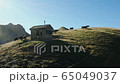 flying in the mountains of Austria over a hut with cows and beautiful views 65049037