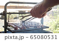 man having barbecue party, outdoors 65080531