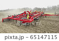 cultivator plows the ground on the field in the spring 65147115