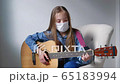 Playing guitar at home in quarantine time. Young girl stay at home alone 65183994