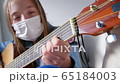 Playing guitar at home in quarantine time. Young girl stay at home alone. Cinematic 65184003