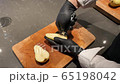 Male chef prepares a dessert of pear and cuts the middle with a bone 65198042