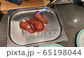 Male chef caramelizes a tomist pear on a metal vessel 65198044