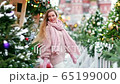 Blonde with long hair on a new years winter day on the background of a decorated city 65199000
