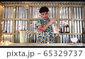 Bar tender working in a street food bar shaking cocktail, looping video 4K with animation 65329737