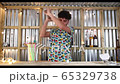 Bar tender working in a street food bar shaking cocktail, looping video 4K with animation 65329738