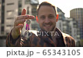 A joyful young man shows the keys to the apartment. concept of buying real estate 65343105