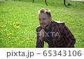 A young man plucked flower from clearing near the business center. The concept of enjoying life in happy day 65343106