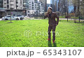 A young man plucked a flower from a clearing near the business center. The concept of enjoying life and a happy day 65343107