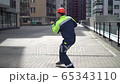 Young cheerful happy builder in an orange helmet and work clothes dancing at construction site. concept of fun worker 65343110