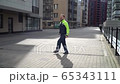 Young male builder in an orange helmet and a jump in work clothes rejoices at a construction site. very happy worker 65343111