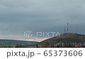 Mountain with a television antenna on a background of a dark clouds sky 65373606