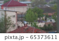 Raindrops falling on a blurry background of roofs 65373611