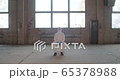 Portrait of young male scientist in protective suit sitting in an abandoned factory during pandemic coronavirus quarantine time with big windows in background 4K 65378988