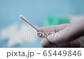 Close up of nurse with white gloves holding swab for coronavirus testing. Medical environment. 65449846