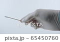 Doctor with white gloves holding swab for coronavirus testing. Close up on white background. 65450760