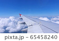 Wing of aircraft flying above blue sky clouds background.Flight travel to dream destination. 65458240