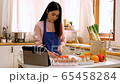 Asian cute woman cooking in kitchen and watch food tutorial course on tablet 65458284