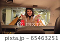The girl smiles and holds packages with purchases in her hands 65463251