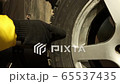 Woman shows rotation direction on a tire when changes car wheel 65537435