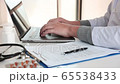 Doctor using laptop at desk in clinic working on computer at room office. 65538433