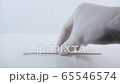 Placeing a swab for covid testing on a white surface. 65546574