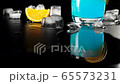 Blue cocktail. Camera slides up on glass with blue summer cocktail on the black table decorated with an orange slice and ice cubes against black background. Concept of alcohol cocktail party. 4K 65573231