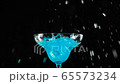 Blue cocktail. Cold ice cubes in slow motion fall into a glass with blue summer cocktail in cocktail glass on the black table against black background. Concept of alcohol cocktail party and nightlife 65573234