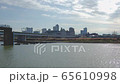 東京都　穏やかな多摩川の水流とビル群 65610998