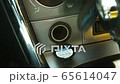 Woman plugs in a pump to a cigarette lighter after changing a car wheel 65614047