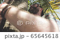Man clambers on palm tree 65645618
