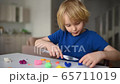 Little boy playing dough at home during coronavirus quarantine. Child molding from plasticine.  65711019