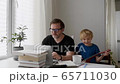 Man working from home with laptop during quarantine. Home office and parenthood at same time. 65711030