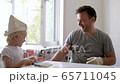 Mature man and little boy having fun with paint brush during repair of room together. 65711045